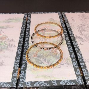 2 fashion bangles with orange beads, and 1 fashion bangle with black beads